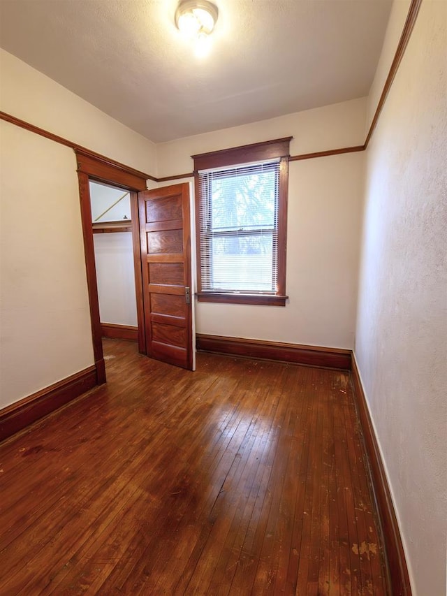 unfurnished bedroom with wood-type flooring and baseboards
