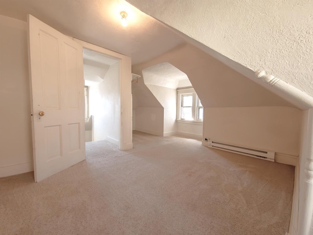 bonus room featuring a baseboard heating unit, carpet flooring, lofted ceiling, a textured ceiling, and baseboards