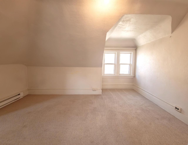 bonus room featuring vaulted ceiling, light carpet, and baseboards
