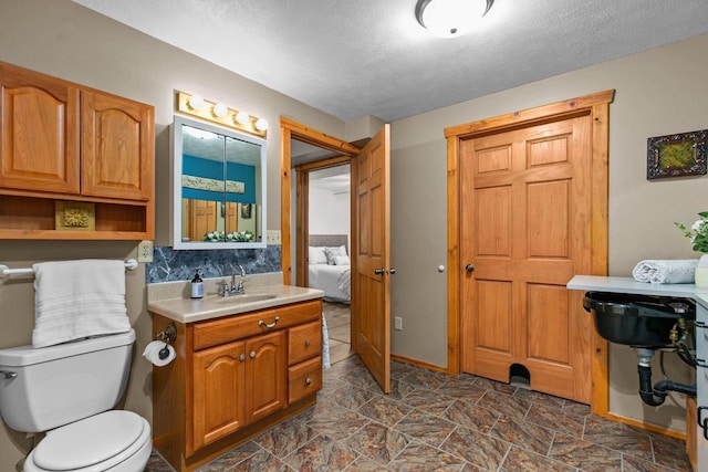 W3161 Julianna Ct, Chilton, WI 53014 - bathroom with toilet, a textured ceiling, ensuite bathroom, and vanity