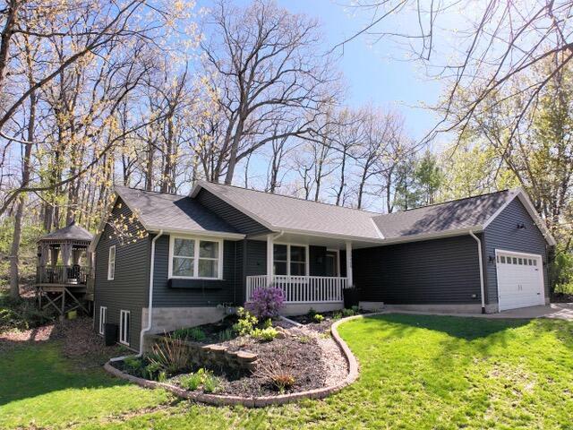 30409 Barnes Ln, Waterford, WI 53185 - ranch-style house featuring a porch, a garage, and a front lawn