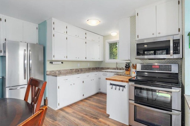 6300 Painter Rd, Mound, MN 55364 - kitchen with stainless steel appliances, a sink, white cabinets, and tasteful backsplash