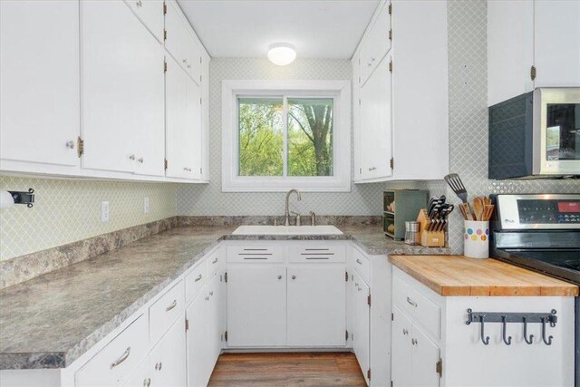 6300 Painter Rd, Mound, MN 55364 - kitchen with appliances with stainless steel finishes, a sink, backsplash, and white cabinets