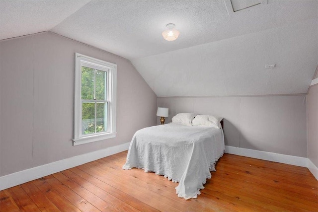 6300 Painter Rd, Mound, MN 55364 - bedroom featuring baseboards, lofted ceiling, a textured ceiling, and wood-type flooring