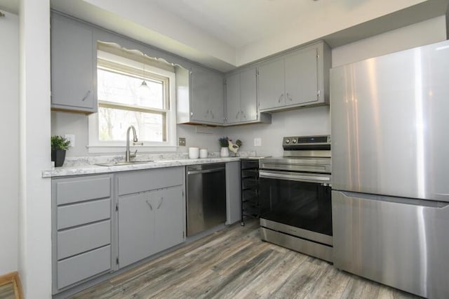 2334 W Custer Ave, Glendale, WI 53209 - kitchen with stainless steel appliances, gray cabinets, a sink, and wood finished floors