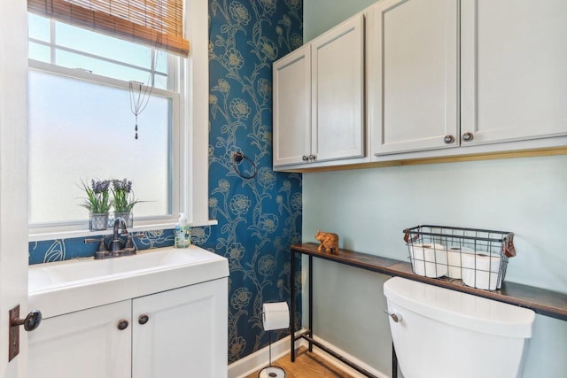 114 E Washington St, West Bend, WI 53095 - half bath with wallpapered walls, toilet, vanity, and baseboards