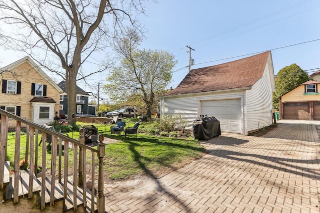 114 E Washington St, West Bend, WI 53095 - view of side of property featuring an outbuilding, a detached garage, and a yard