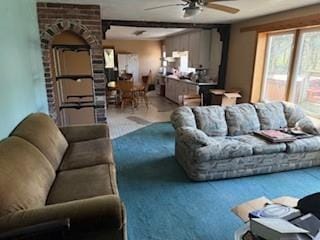 living area with a ceiling fan and carpet flooring