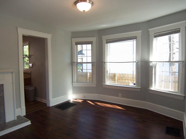 929 Park Ave, Beloit, WI 53511 - unfurnished dining area featuring dark wood finished floors, healthy amount of natural light, and baseboards