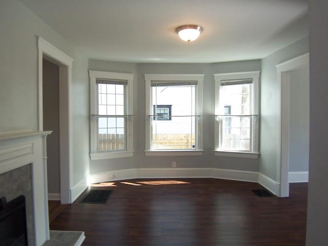 929 Park Ave, Beloit, WI 53511 - unfurnished living room featuring dark wood-type flooring, a fireplace, and baseboards