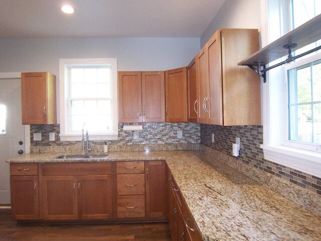 929 Park Ave, Beloit, WI 53511 - kitchen featuring a sink, brown cabinets, light stone counters, backsplash, and dark wood-style flooring