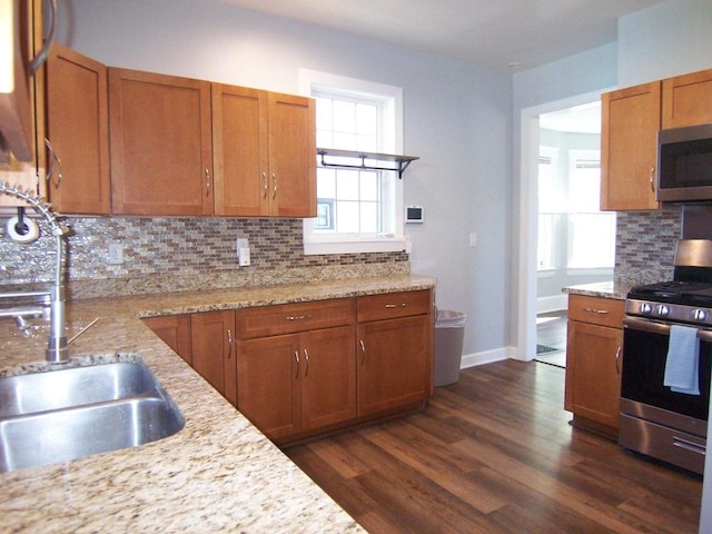 929 Park Ave, Beloit, WI 53511 - kitchen with appliances with stainless steel finishes, a sink, tasteful backsplash, dark wood-type flooring, and brown cabinets