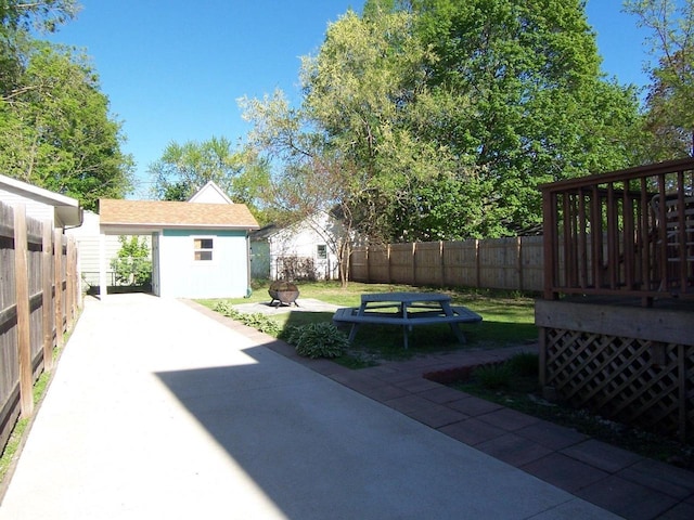 929 Park Ave, Beloit, WI 53511 - fenced backyard featuring an outdoor fire pit, an outdoor structure, a wooden deck, a patio area, and a shed