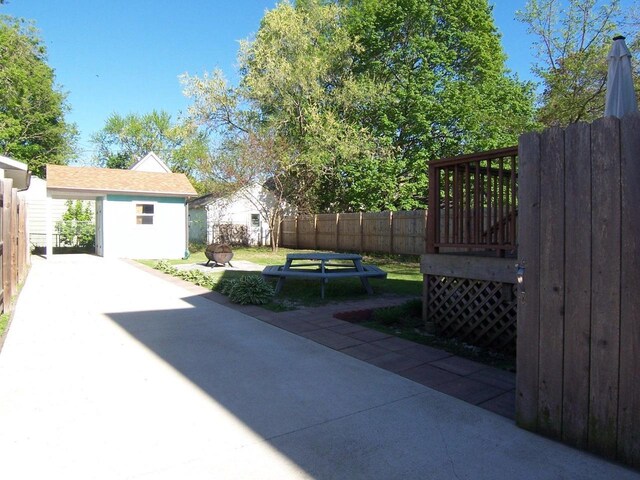 929 Park Ave, Beloit, WI 53511 - view of patio / terrace featuring an outdoor fire pit, an outdoor structure, a fenced backyard, and a storage unit