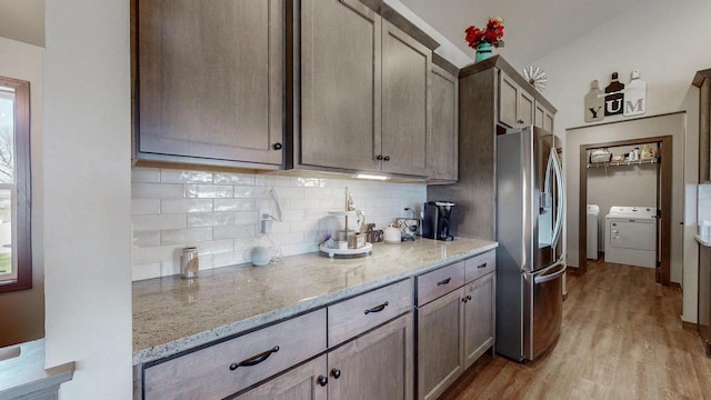 2239 E Honeygold Ct, Appleton, WI 54913 - kitchen with stainless steel fridge with ice dispenser, washer and clothes dryer, backsplash, light wood-type flooring, and light stone countertops