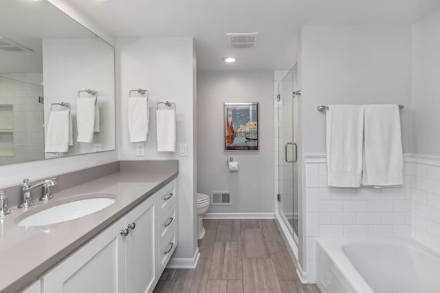 2305 W County Line Rd, River Hills, WI 53217 - bathroom featuring a shower stall, vanity, toilet, wood finished floors, and a tub
