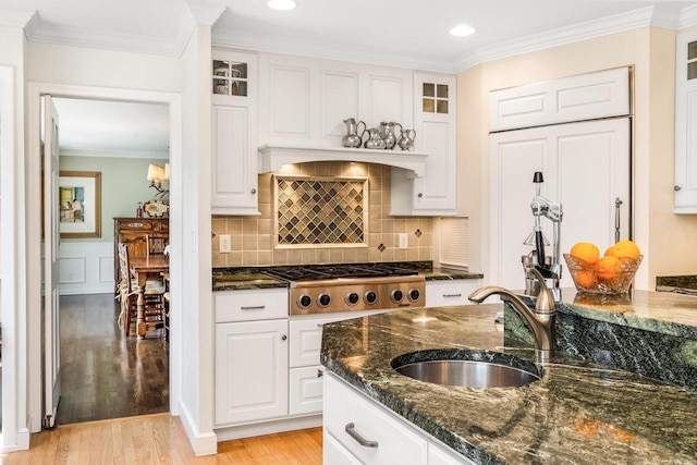 2305 W County Line Rd, River Hills, WI 53217 - kitchen with stainless steel gas stovetop, light wood-style flooring, white cabinetry, dark stone countertops, and ornamental molding