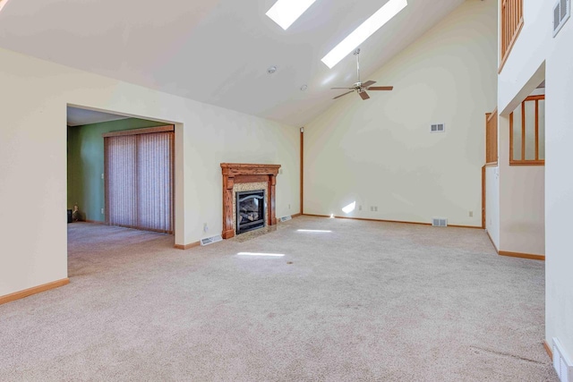 8200 43rd Ave, Kenosha, WI 53142 - unfurnished living room featuring carpet flooring, a skylight, ceiling fan, a fireplace with flush hearth, and baseboards
