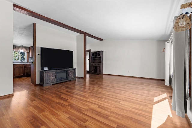 3500 W Justin St, Appleton, WI 54914 - unfurnished living room featuring wood finished floors, baseboards, and a sink