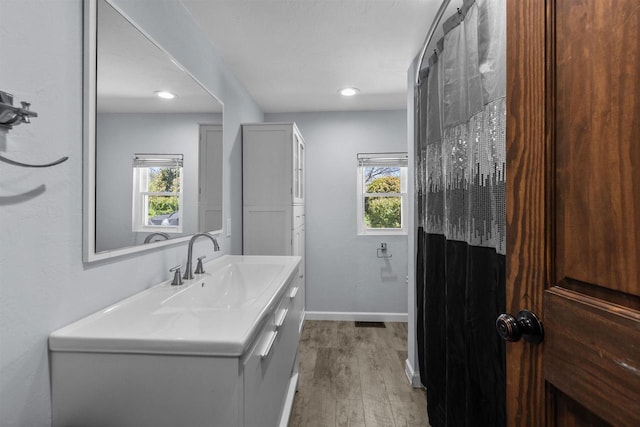 3500 W Justin St, Appleton, WI 54914 - bathroom featuring wood finished floors, healthy amount of natural light, vanity, baseboards, and recessed lighting