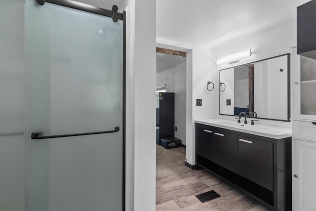 3500 W Justin St, Appleton, WI 54914 - full bathroom featuring wood finished floors, vanity, and a shower with door