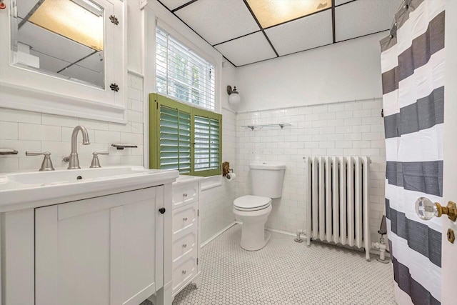 215 W Walworth St, Elkhorn, WI 53121 - bathroom featuring radiator, tile walls, toilet, vanity, and tile patterned flooring