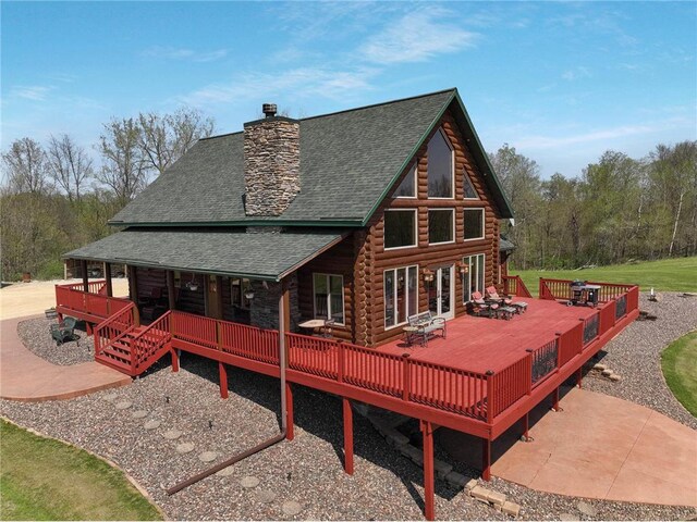 N5502 90th St, Elmwood, WI 54740 - rear view of property featuring a shingled roof, log exterior, a chimney, and a deck