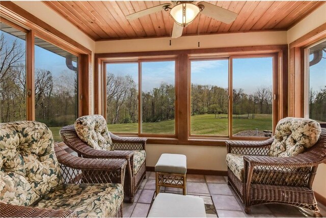 N5502 90th St, Elmwood, WI 54740 - sunroom / solarium with tile patterned floors, baseboards, wood ceiling, and view of scattered trees