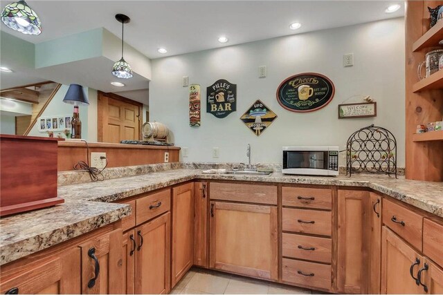 N5502 90th St, Elmwood, WI 54740 - kitchen featuring white microwave, a sink, open shelves, decorative light fixtures, and brown cabinets