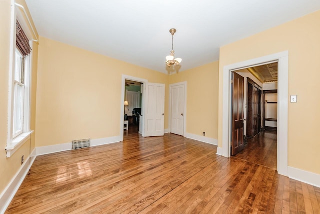 12220 W Highland Rd, Mequon, WI 53097 - unfurnished room featuring light wood-style floors, a chandelier, healthy amount of natural light, and baseboards