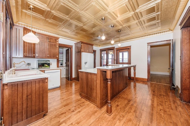 12220 W Highland Rd, Mequon, WI 53097 - kitchen with white appliances, a sink, an ornate ceiling, baseboards, and a kitchen island