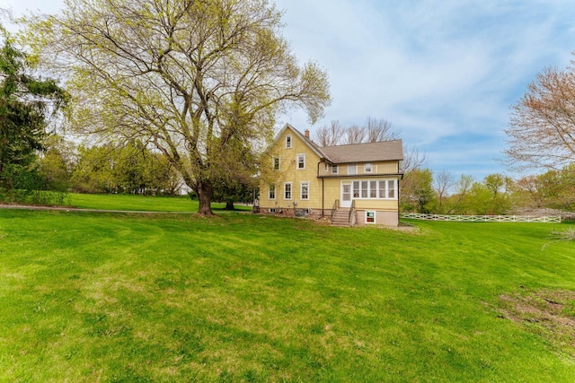 12220 W Highland Rd, Mequon, WI 53097 - rear view of house featuring a yard, entry steps, and a chimney