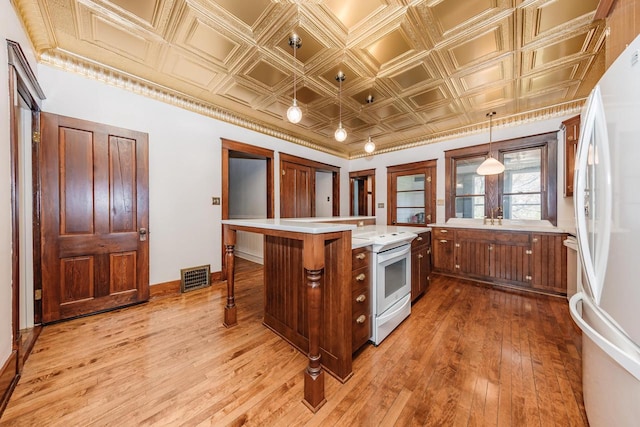 12220 W Highland Rd, Mequon, WI 53097 - kitchen featuring white appliances, light wood finished floors, light countertops, an ornate ceiling, and brown cabinetry