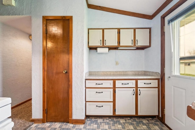 N8584 Snake Rd, Elkhart Lake, WI 53020 - kitchen featuring a textured wall, light countertops, vaulted ceiling, and baseboards