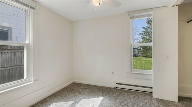 empty room with a baseboard radiator, carpet floors, ceiling fan, and baseboards