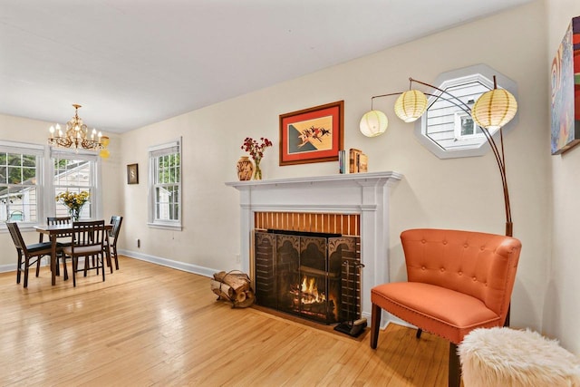 4105 Meyer Ave, Madison, WI 53711 - dining room with hardwood / wood-style floors, a chandelier, a brick fireplace, and baseboards