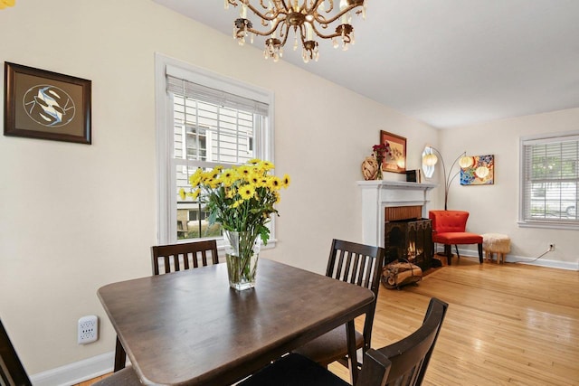 4105 Meyer Ave, Madison, WI 53711 - dining space with a chandelier, baseboards, a brick fireplace, and wood finished floors
