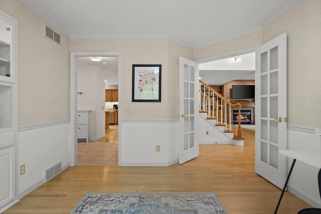 956 Kingston Cir, Sun Prairie, WI 53590 - hall with french doors, stairway, light wood finished floors, and ornamental molding