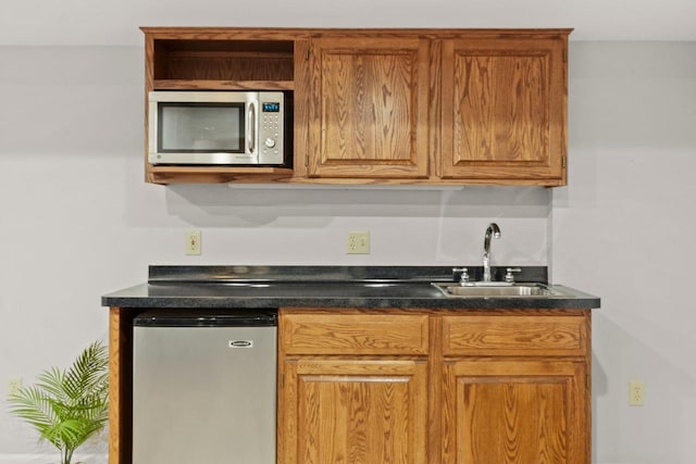 956 Kingston Cir, Sun Prairie, WI 53590 - kitchen with stainless steel microwave, a sink, refrigerator, and dark countertops