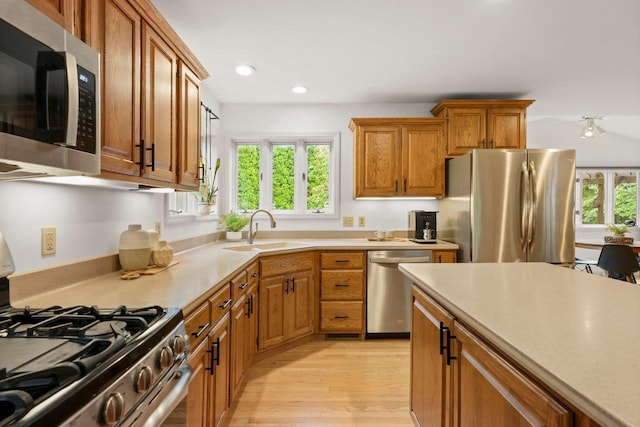 956 Kingston Cir, Sun Prairie, WI 53590 - kitchen with appliances with stainless steel finishes, a sink, light wood-style flooring, light countertops, and recessed lighting