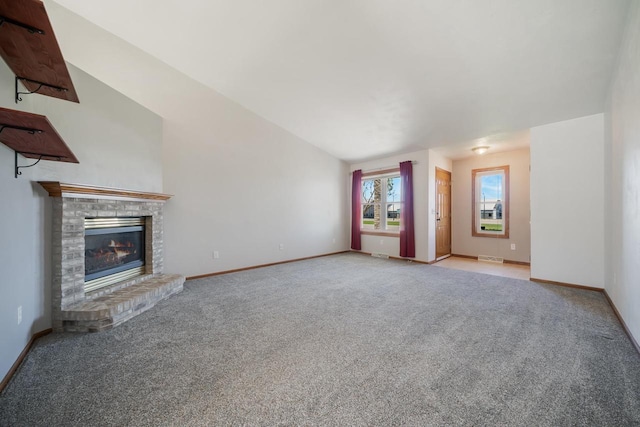 unfurnished living room with carpet floors, baseboards, and a fireplace