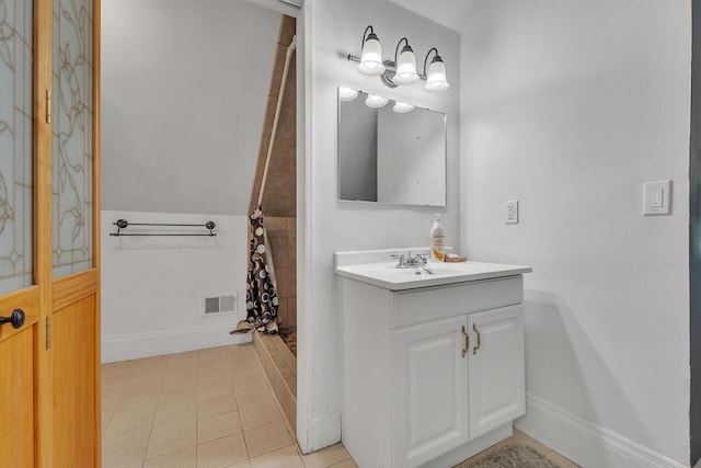 1235 Grove Ave, Racine, WI 53405 - bathroom with a tile shower, vanity, baseboards, and tile patterned floors