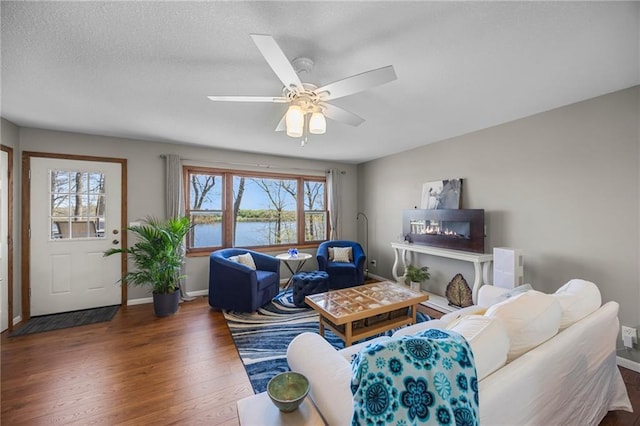1141 134th Ave, Amery, WI 54001 - living room with wood finished floors, baseboards, a water view, a ceiling fan, and a textured ceiling