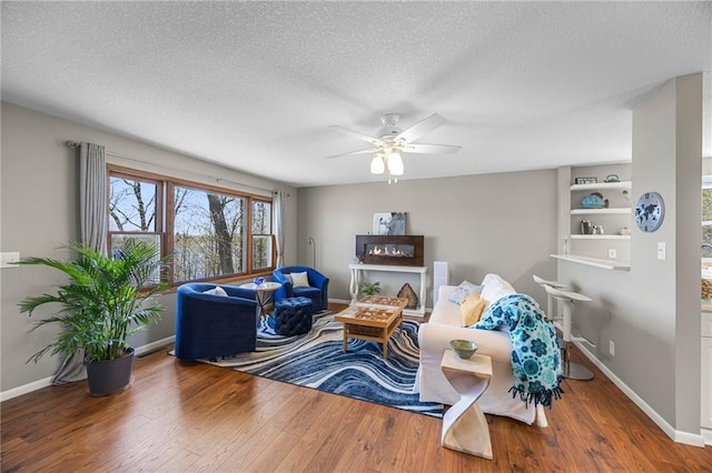 1141 134th Ave, Amery, WI 54001 - living area with wood finished floors, ceiling fan, baseboards, and a textured ceiling