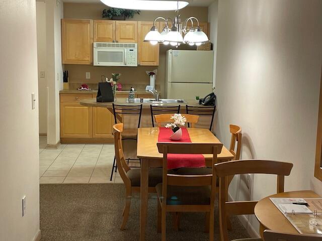 123 Center St Unit 101, Lake Geneva, WI 53147 - dining area featuring light carpet and light tile patterned floors