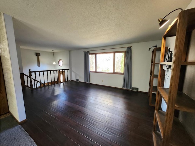 1451 90th Ave, Amery, WI 54001 - spare room featuring a textured ceiling and dark wood-style floors
