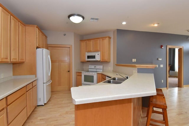 110 S Wisconsin St Unit 2E, Port Washington, WI 53074 - kitchen with white appliances, a sink, light wood finished floors, light brown cabinetry, and recessed lighting