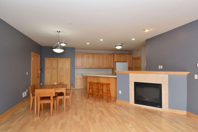 110 S Wisconsin St Unit 2E, Port Washington, WI 53074 - kitchen featuring freestanding refrigerator, light wood finished floors, baseboards, light countertops, and a kitchen breakfast bar