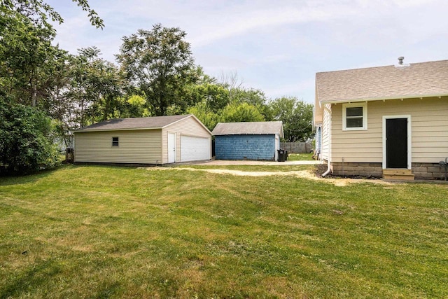932 Washburn St, Beloit, WI 53511 - view of grassy yard with entry steps, a garage, and an outbuilding