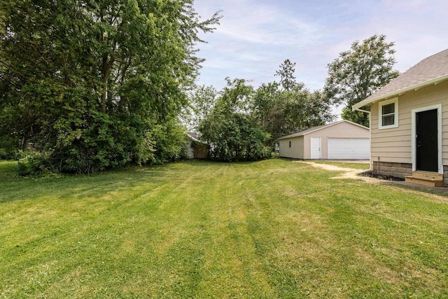 932 Washburn St, Beloit, WI 53511 - view of grassy yard with a detached garage, an outbuilding, and entry steps
